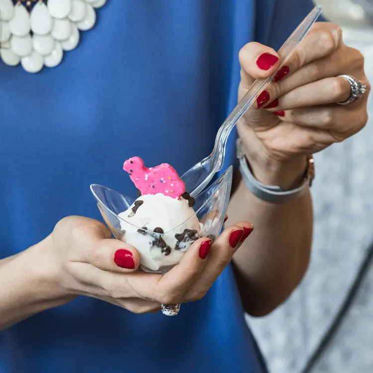 Woman in formal attire smiling while holding smoking mocktail drinks